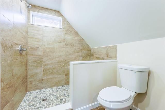 bathroom featuring tiled shower, vaulted ceiling, and toilet