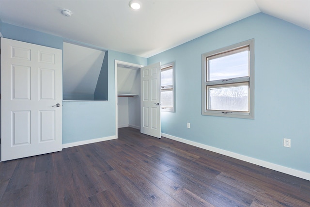 unfurnished bedroom featuring dark hardwood / wood-style floors, a closet, and lofted ceiling