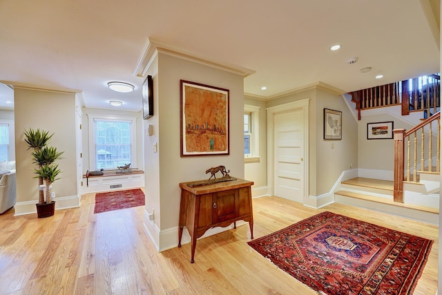 hallway with light hardwood / wood-style flooring and ornamental molding