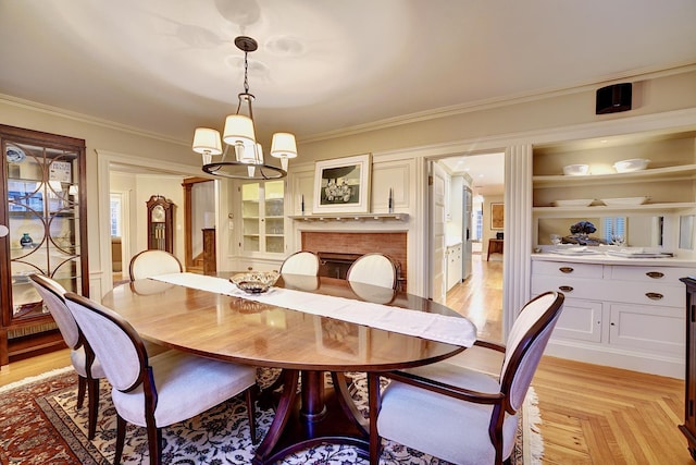 dining area with ornamental molding, light parquet floors, and a notable chandelier