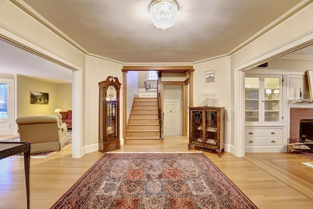 interior space featuring a chandelier, light hardwood / wood-style flooring, and ornamental molding