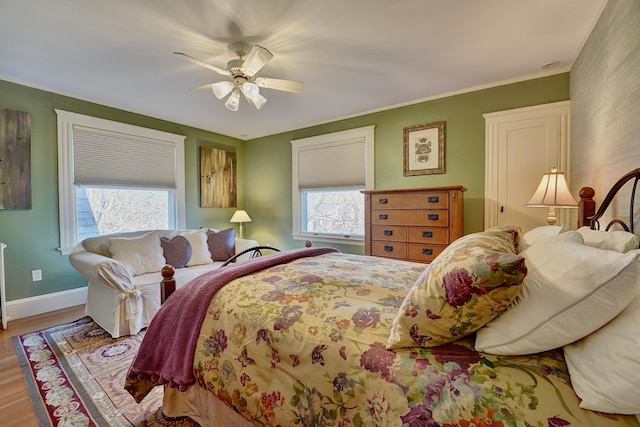 bedroom with multiple windows, ceiling fan, and light hardwood / wood-style floors