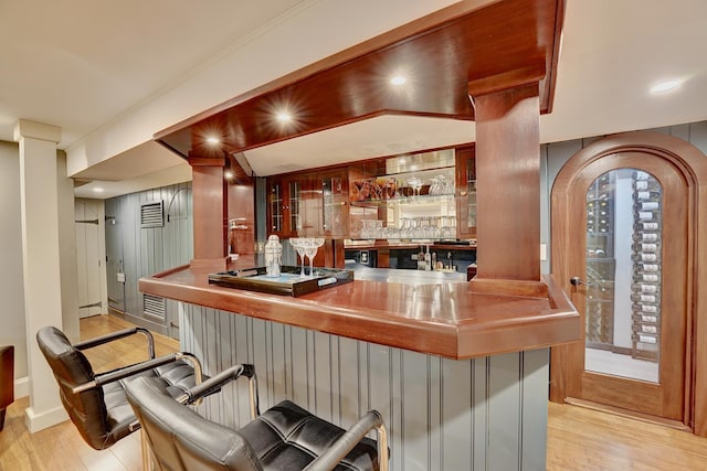 bar with crown molding and light hardwood / wood-style floors