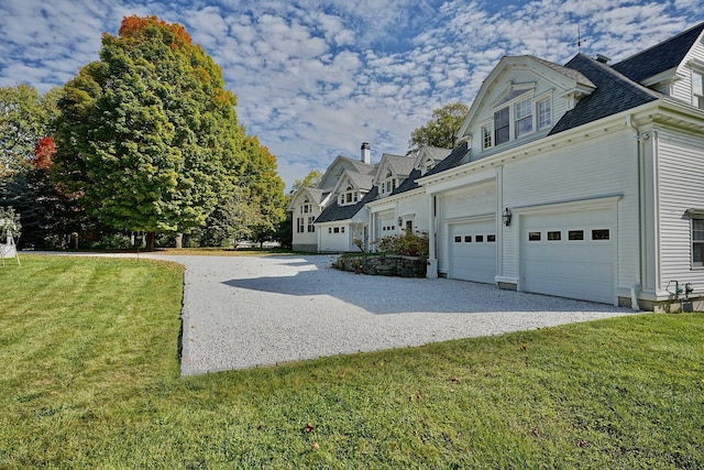 view of side of property featuring a lawn and a garage