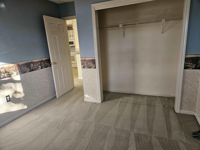 unfurnished bedroom featuring carpet flooring and a closet