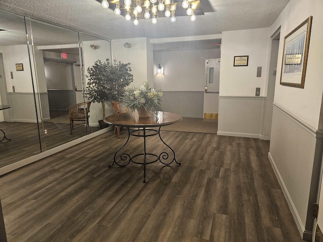 hallway with dark wood-type flooring and a textured ceiling