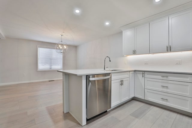 kitchen featuring dishwasher, white cabinetry, sink, and kitchen peninsula