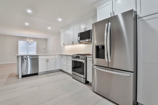 kitchen with pendant lighting, an inviting chandelier, stainless steel appliances, and white cabinetry