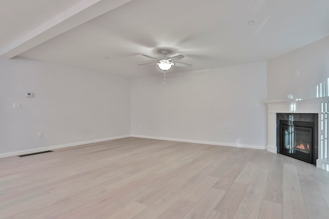 unfurnished living room featuring a fireplace, light hardwood / wood-style flooring, and ceiling fan