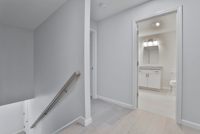 corridor featuring sink and light hardwood / wood-style floors