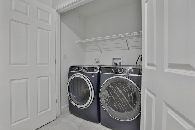 laundry area with light tile patterned floors and washing machine and dryer