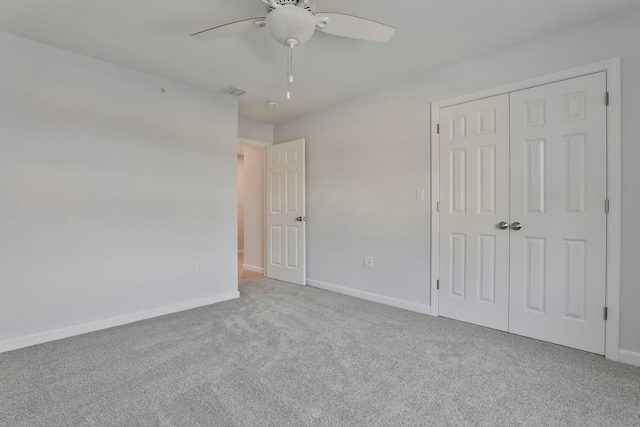 unfurnished bedroom featuring ceiling fan, light colored carpet, and a closet