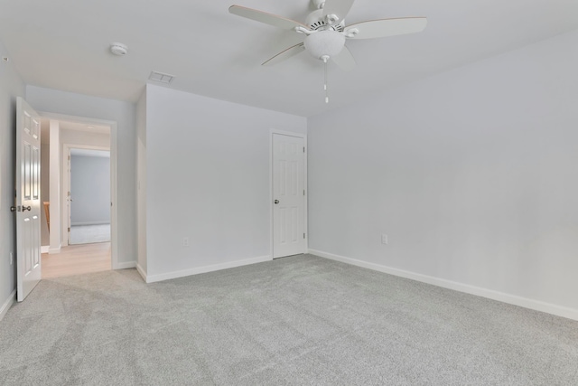 spare room featuring light carpet and ceiling fan