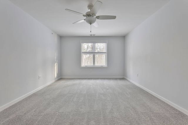 empty room featuring ceiling fan and light colored carpet