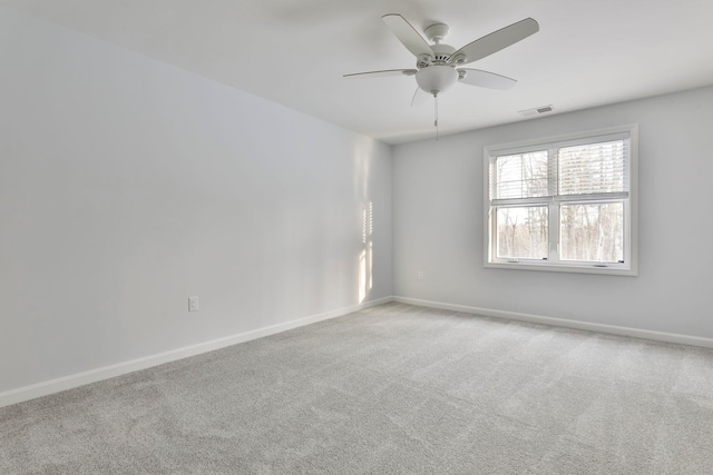 carpeted spare room featuring ceiling fan