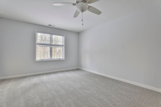 unfurnished room with ceiling fan and carpet