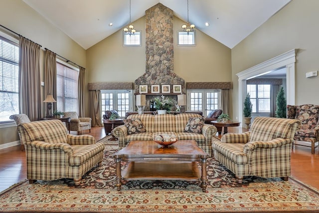 living room with hardwood / wood-style flooring, high vaulted ceiling, and an inviting chandelier