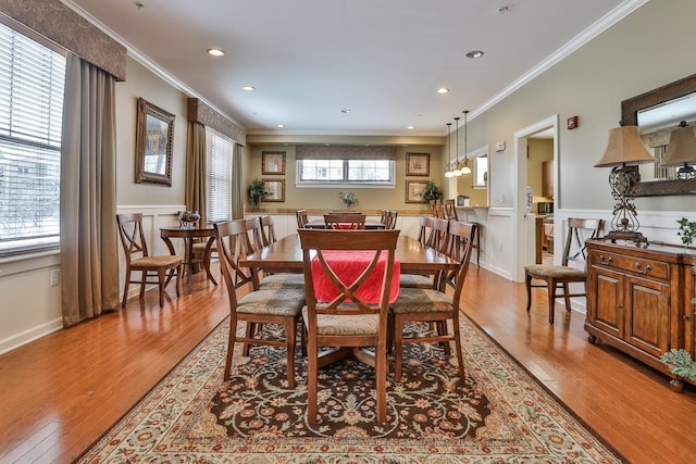 dining space with light hardwood / wood-style floors and ornamental molding