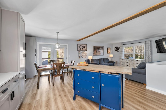 kitchen featuring butcher block countertops, white cabinetry, blue cabinets, and hanging light fixtures