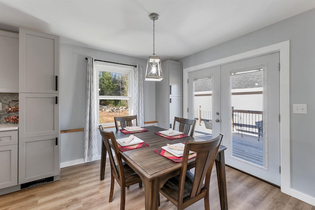 dining area with french doors and light hardwood / wood-style floors