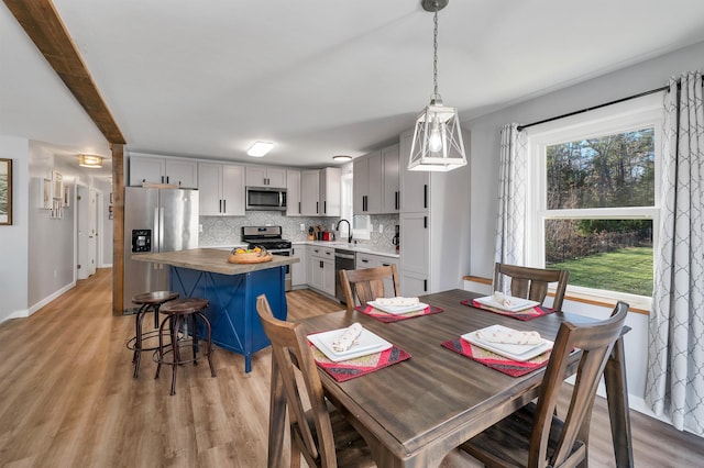 dining area with sink and light wood-type flooring