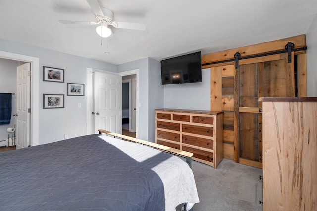 bedroom with carpet flooring, a barn door, and ceiling fan