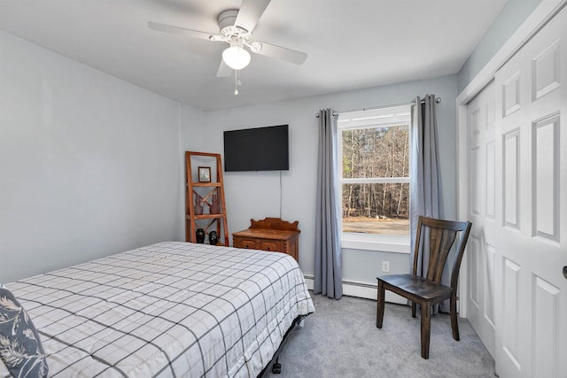 carpeted bedroom featuring baseboard heating, ceiling fan, and a closet