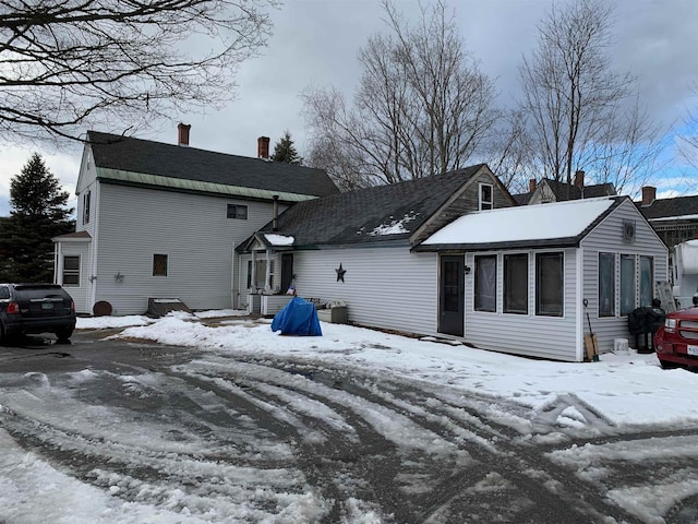 view of snow covered rear of property