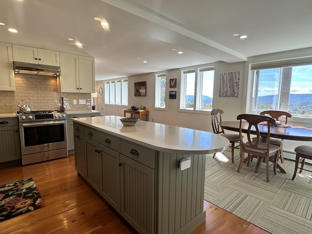 kitchen with gray cabinetry, a kitchen island, white cabinetry, and stainless steel stove