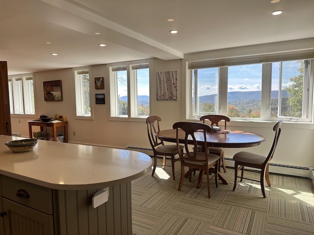 carpeted dining area with a mountain view and baseboard heating