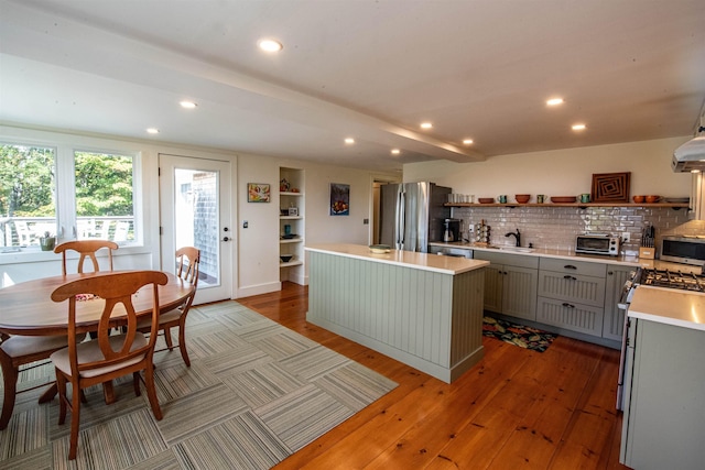 kitchen featuring gray cabinetry, a center island, sink, appliances with stainless steel finishes, and light hardwood / wood-style floors