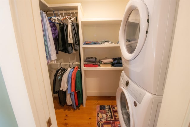 laundry area featuring stacked washer and dryer and light wood-type flooring