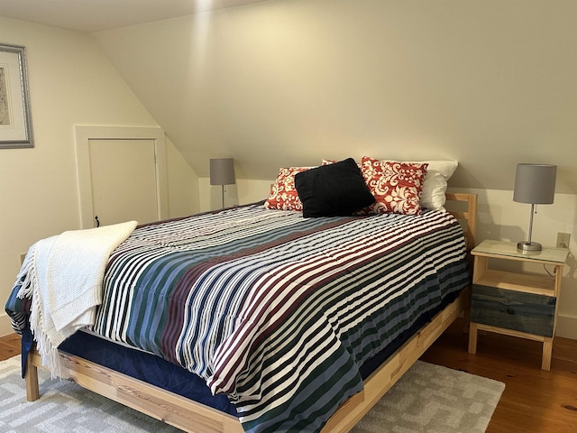 bedroom with wood-type flooring and lofted ceiling