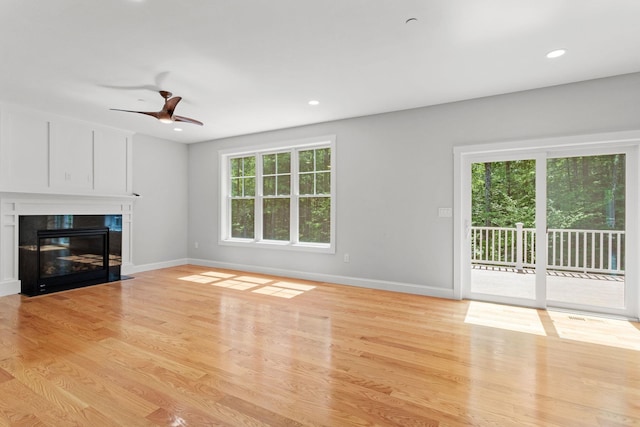 unfurnished living room featuring ceiling fan and light wood-type flooring