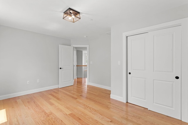 unfurnished bedroom with light hardwood / wood-style flooring and a closet