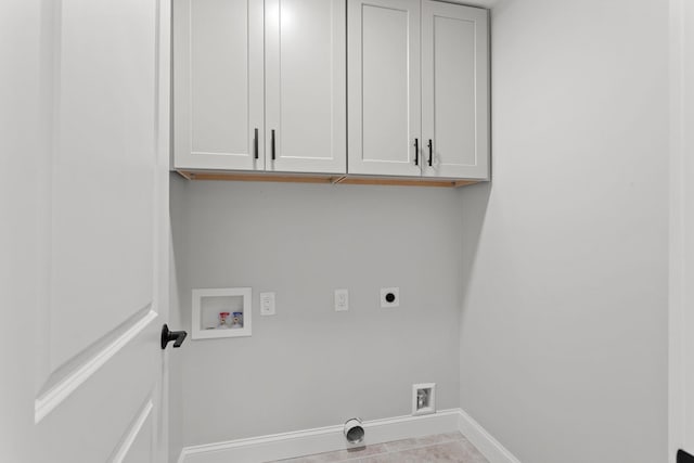 washroom with hookup for an electric dryer, cabinets, light tile patterned floors, and washer hookup