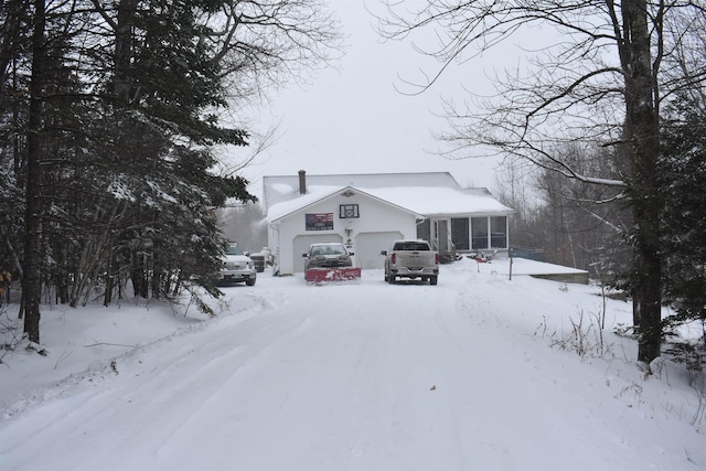 view of front facade featuring a garage and a sunroom