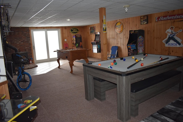 rec room with a wood stove, billiards, wood walls, and carpet flooring