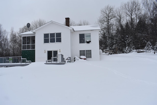 snow covered property with a sunroom