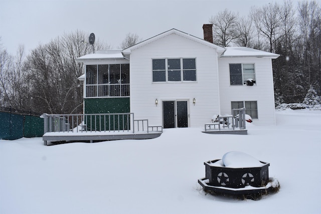 snow covered house with a sunroom