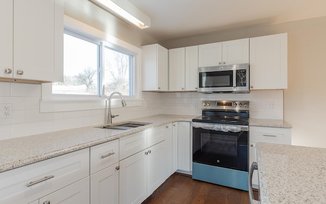 kitchen featuring backsplash, dark wood-type flooring, sink, white cabinetry, and stainless steel appliances