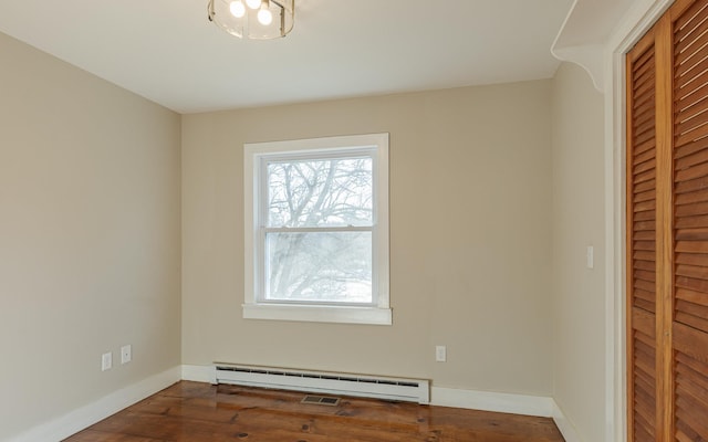 empty room featuring dark hardwood / wood-style floors and a baseboard radiator