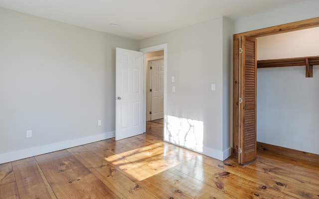 unfurnished bedroom with light hardwood / wood-style floors and a closet