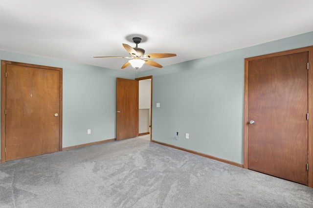 unfurnished bedroom with ceiling fan and light colored carpet