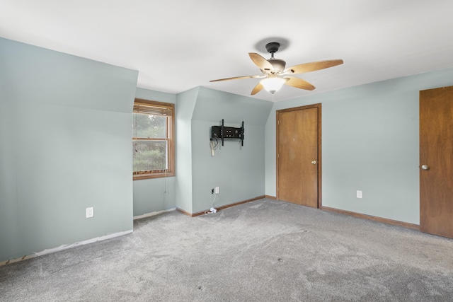 empty room featuring ceiling fan and light carpet