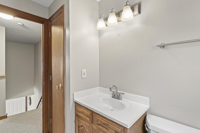 bathroom with vanity, a textured ceiling, and toilet