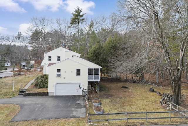 view of side of home featuring a sunroom and a garage