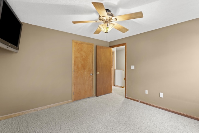 unfurnished bedroom with ceiling fan and light colored carpet