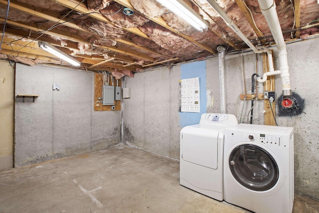 clothes washing area with electric panel and separate washer and dryer