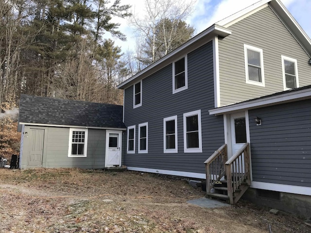 rear view of property featuring a storage shed